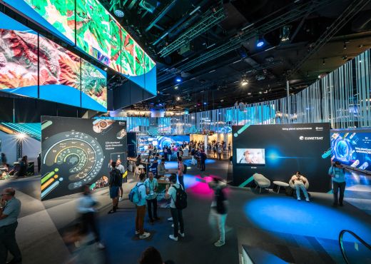 Ein Ausstellungsraum voller Besucher:innen und mit vielen bunten Bildern und Animationen zu Weltraumthemen