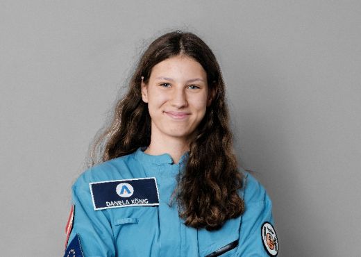 Portrait Daniela König. Sie hat lange braune Haare und trägt einen Space-Anzug.